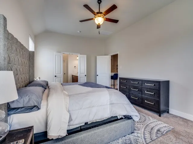 a spacious bedroom with a bed and a chandelier