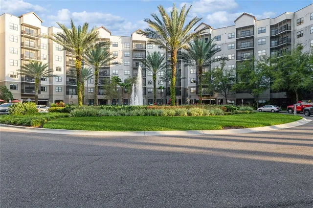 a view of a multi story residential apartment building with a yard