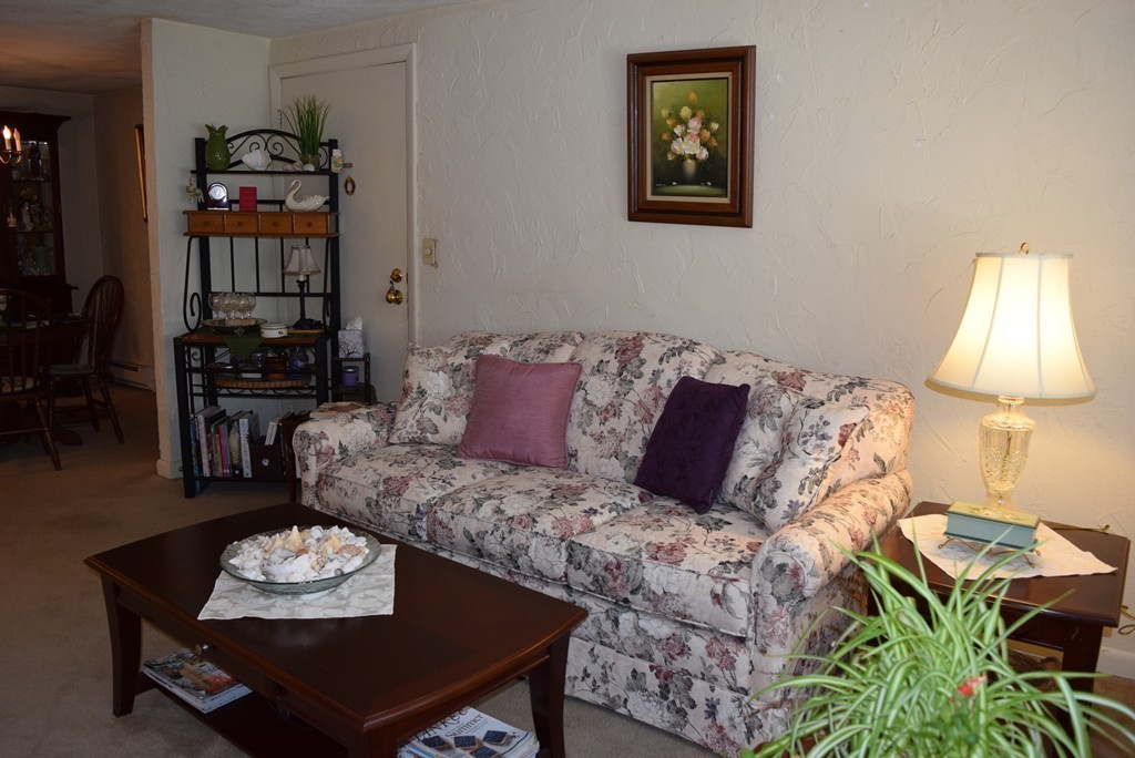 140 Swanson Road, Unit 413 Boxborough, MA 01719 - Photo 4 of 26 a living room with furniture and a lamp