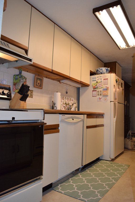 140 Swanson Road, Unit 413 Boxborough, MA 01719 - Photo 9 of 26 a white refrigerator freezer sitting inside of a kitchen