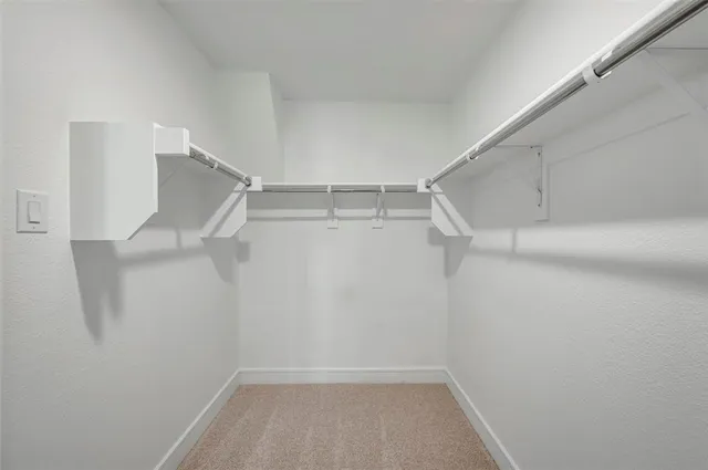 a view of walk in closet with empty racks