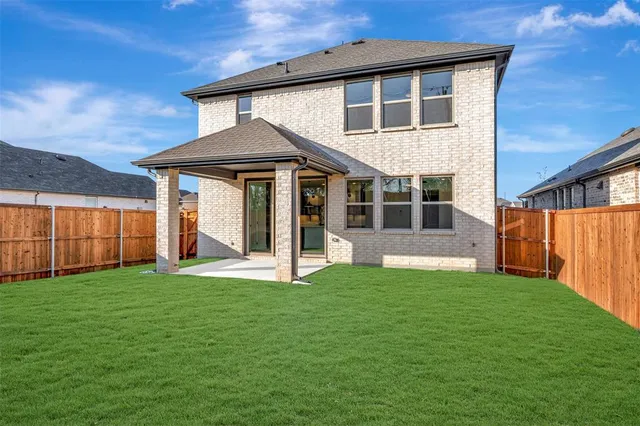 a view of a house with yard and porch with wooden fence