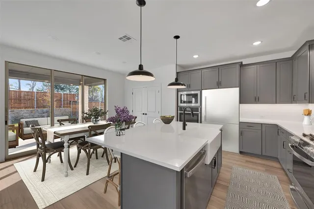 a kitchen with a table chairs microwave and cabinets