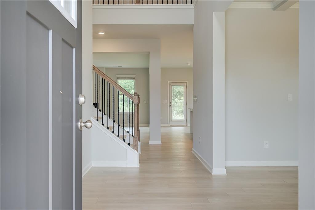 709 Dunlake Way Locust Grove, GA 30248 - Photo 2 of 34 a view of a hallway with wooden floor and staircase