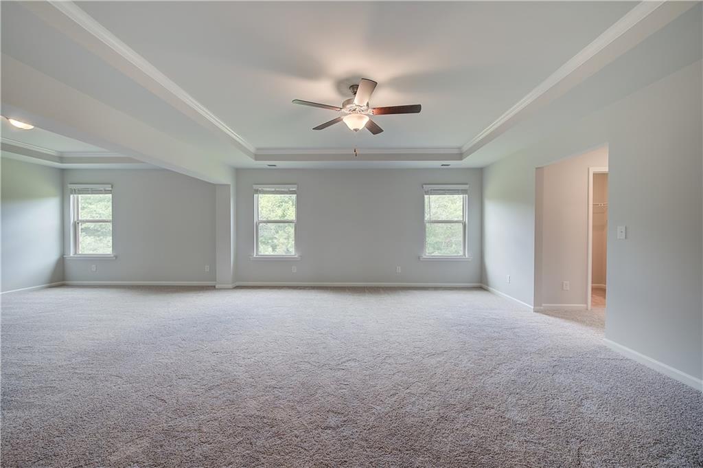 709 Dunlake Way Locust Grove, GA 30248 - Photo 23 of 34 an empty room with windows and ceiling fan