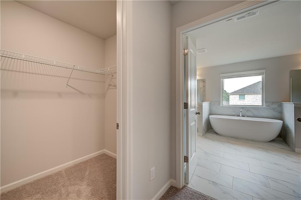 709 Dunlake Way Locust Grove, GA 30248 - Photo 28 of 34 a bathroom with a white tub shower and mirror