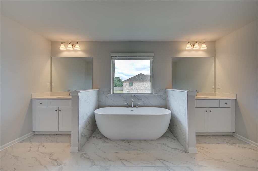 709 Dunlake Way Locust Grove, GA 30248 - Photo 29 of 34 a spacious bathroom with a bathtub and sink