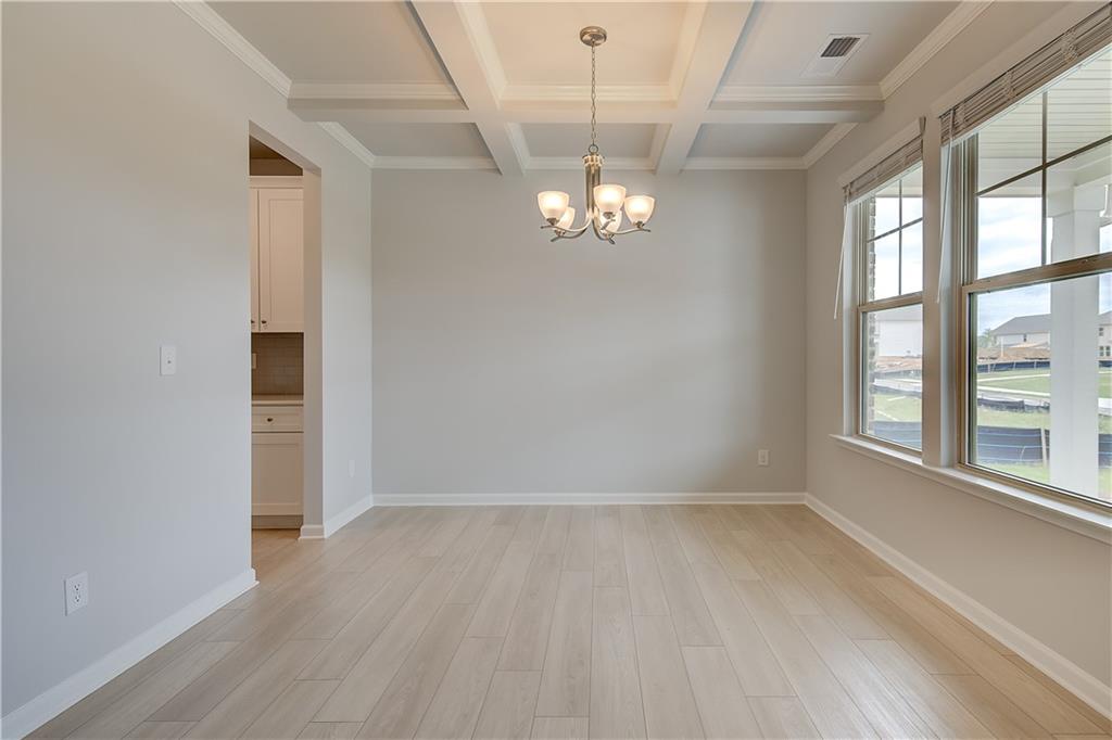 709 Dunlake Way Locust Grove, GA 30248 - Photo 3 of 34 wooden floor in an empty room with a window