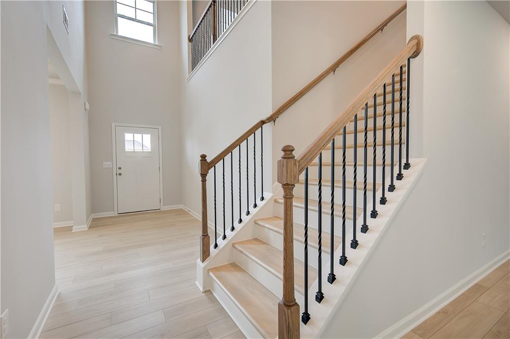 709 Dunlake Way Locust Grove, GA 30248 - Photo 4 of 34 a view of staircase with lots of frames on wall and windows