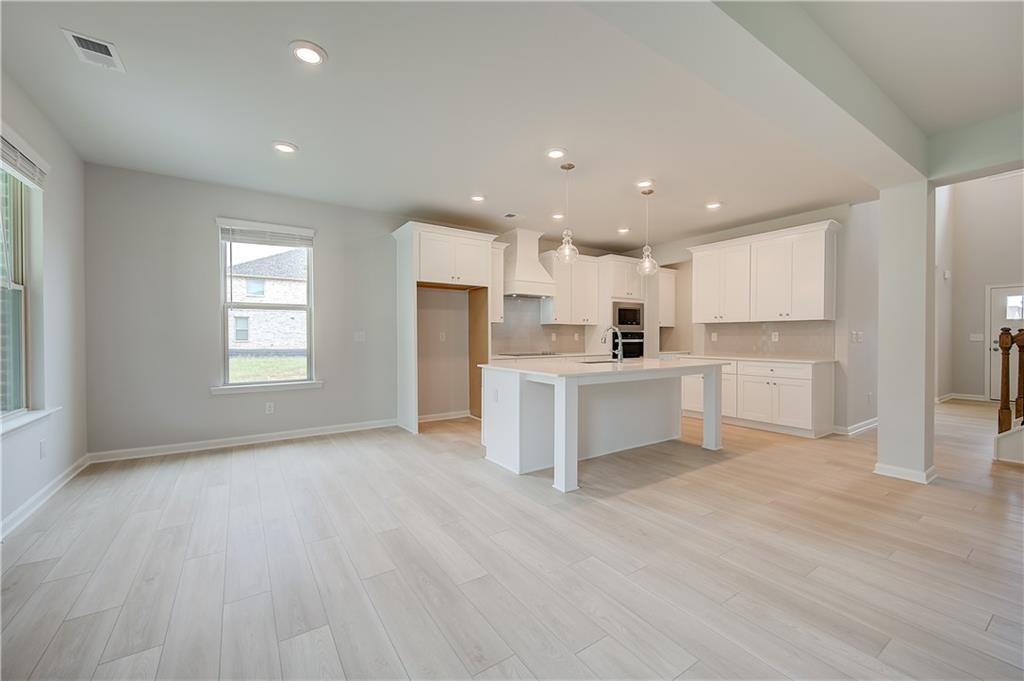 709 Dunlake Way Locust Grove, GA 30248 - Photo 7 of 34 a view of a kitchen with a sink and dishwasher a refrigerator with wooden floor