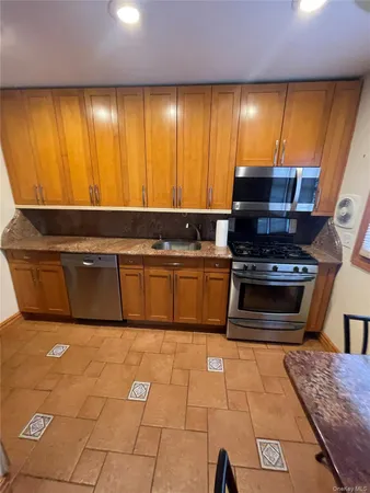 a kitchen with stainless steel appliances granite countertop a stove a sink and a microwave