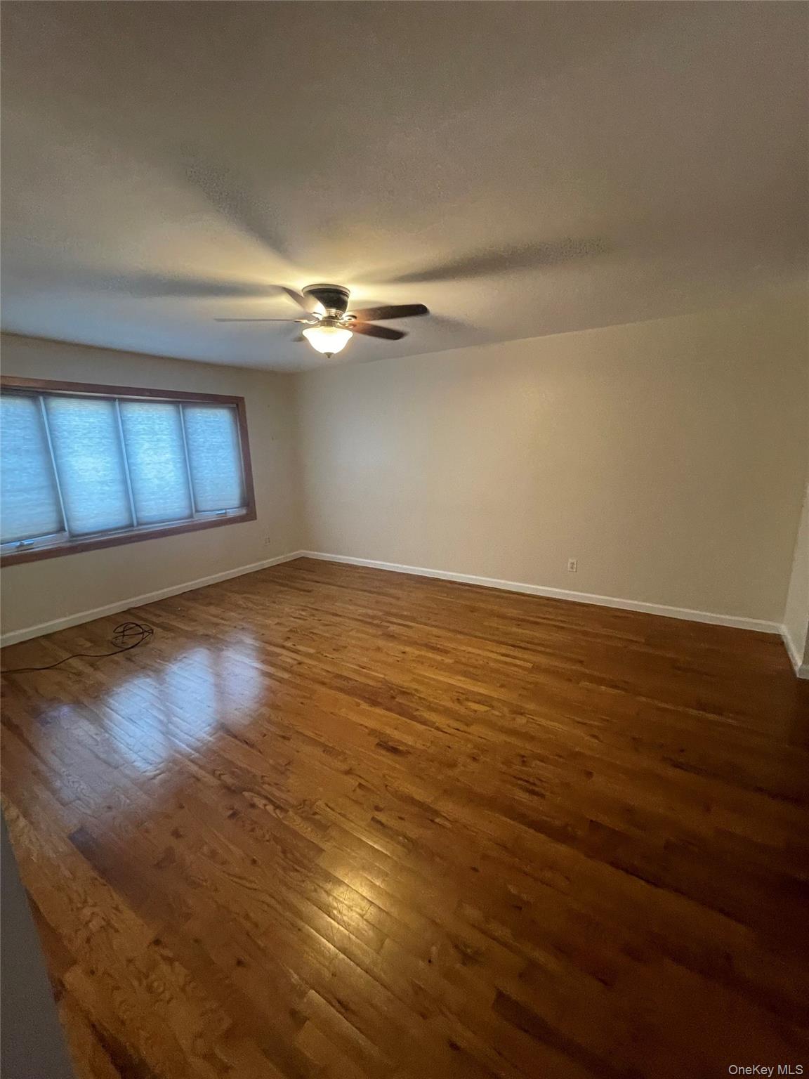 20-23 Whitestone Expressway Queens, NY 11357 - Photo 18 of 28 a view of an empty room with window and wooden floor