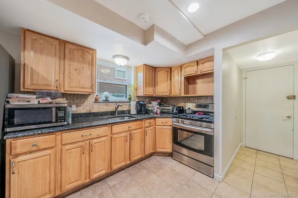 a kitchen with stainless steel appliances granite countertop a stove sink and cabinets