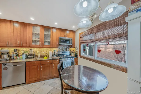 a kitchen with sink a refrigerator and chairs