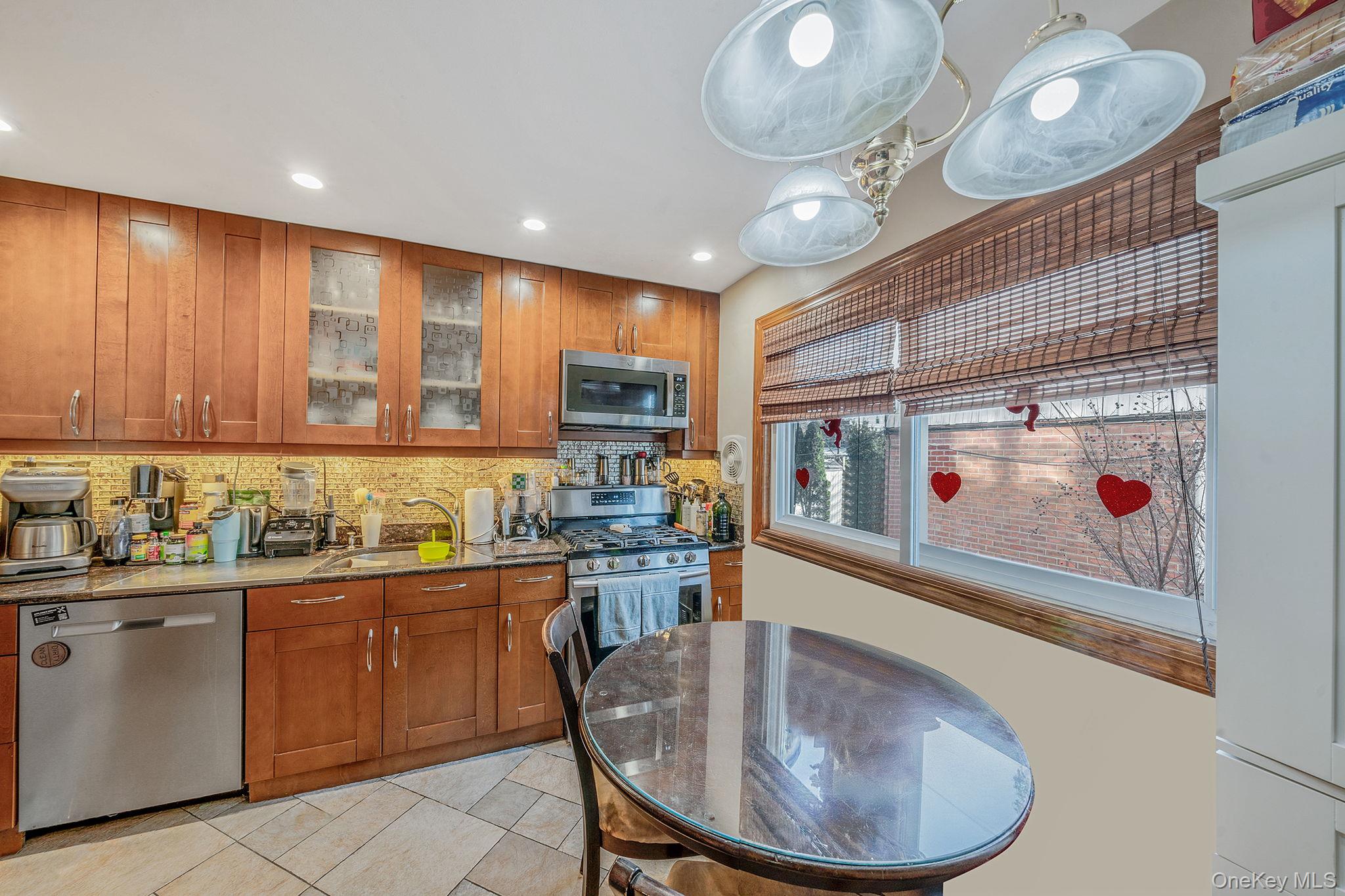 20-23 Whitestone Expressway Queens, NY 11357 - Photo 2 of 28 a kitchen with sink a refrigerator and chairs