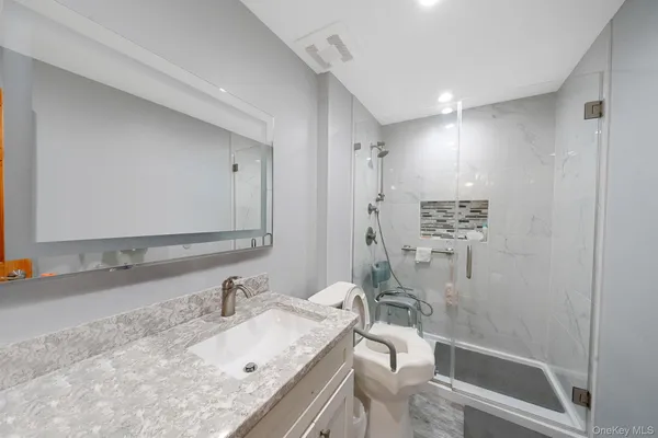 a bathroom with a granite countertop sink mirror vanity and bathtub