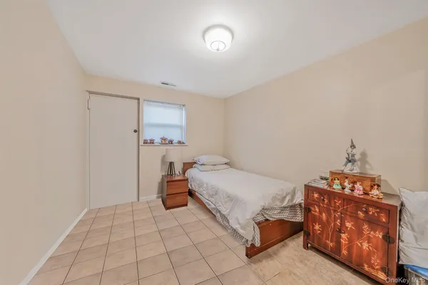 a bedroom with a bed and a lamp on the dresser