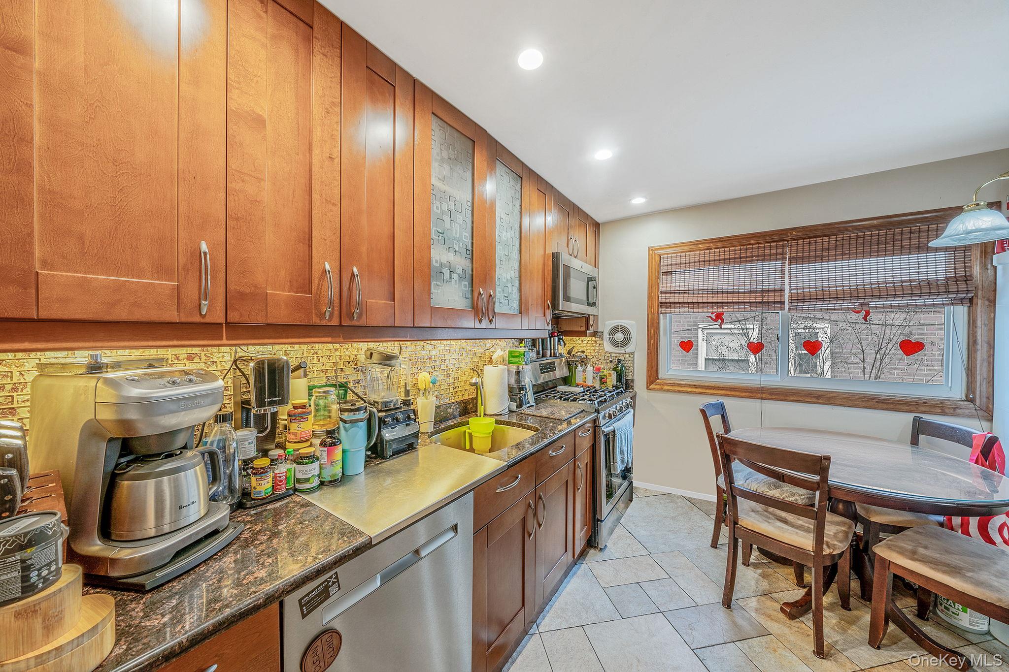 20-23 Whitestone Expressway Queens, NY 11357 - Photo 3 of 28 a kitchen with a sink and wooden cabinets