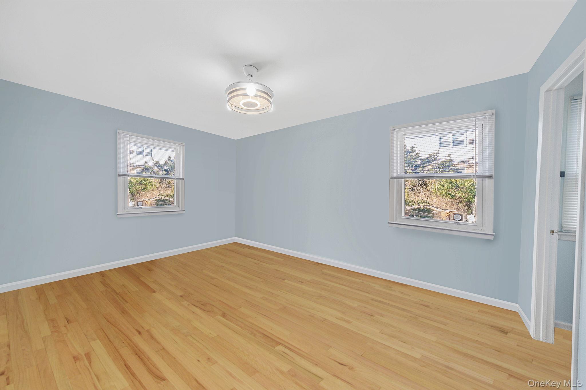 20-23 Whitestone Expressway Queens, NY 11357 - Photo 8 of 28 a view of an empty room with wooden floor and a window