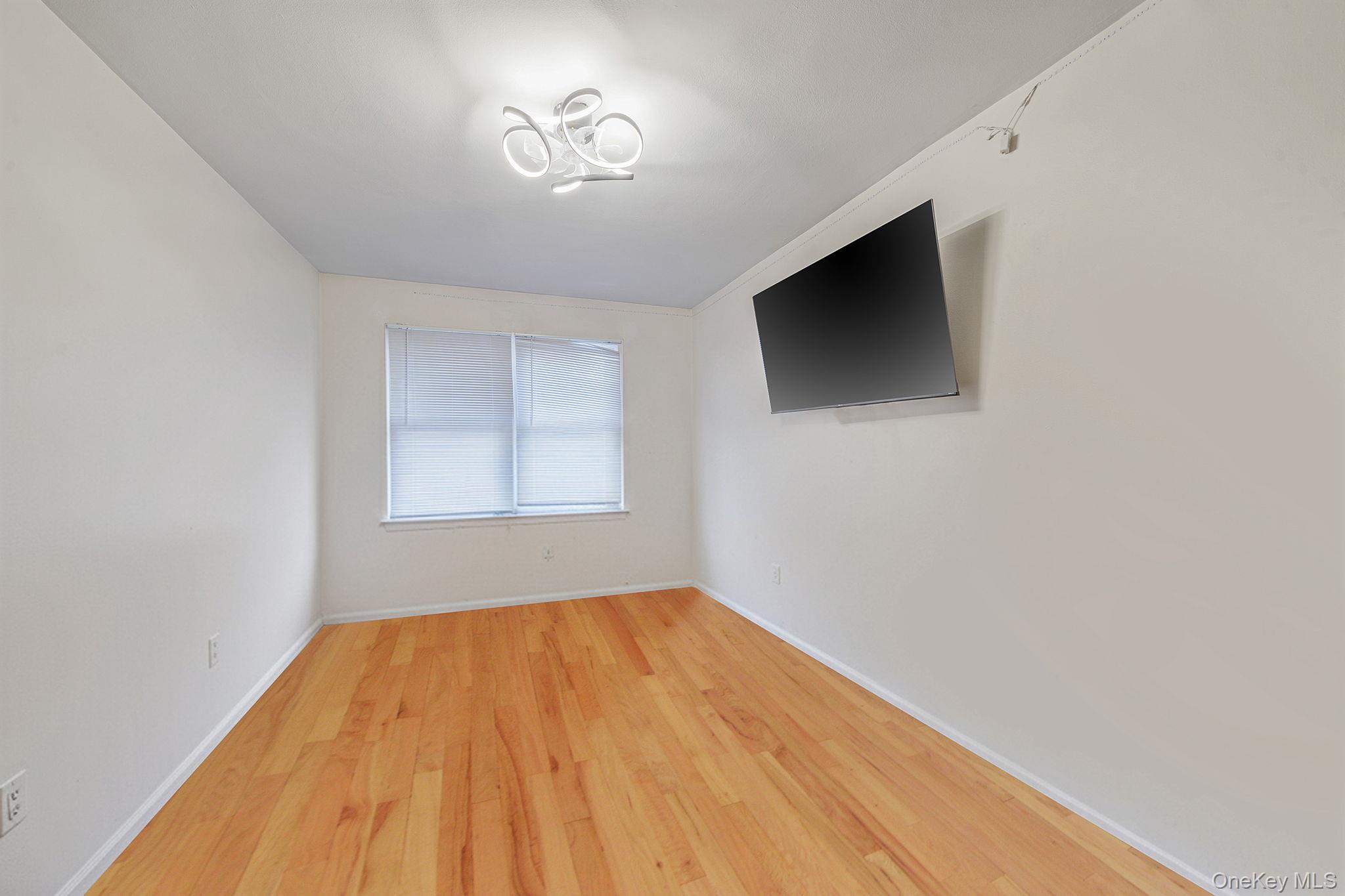 20-23 Whitestone Expressway Queens, NY 11357 - Photo 9 of 28 a view of empty room with wooden floor and fan