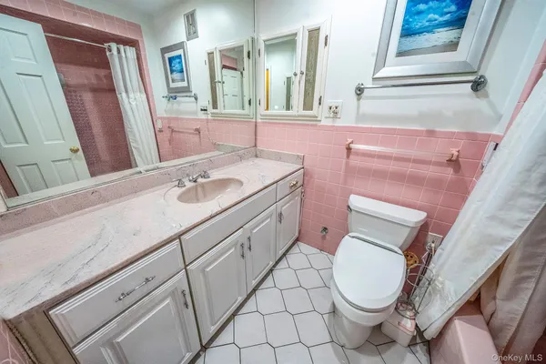 a bathroom with a sink a toilet and a mirror