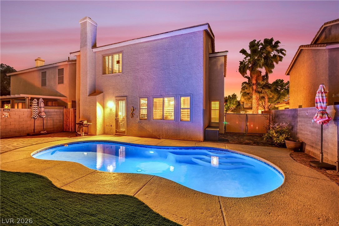 1724 Millstream Way Henderson, NV 89074 - Photo 50 of 60 A private backyard oasis with a shimmering pool beckons under a twilight sky.