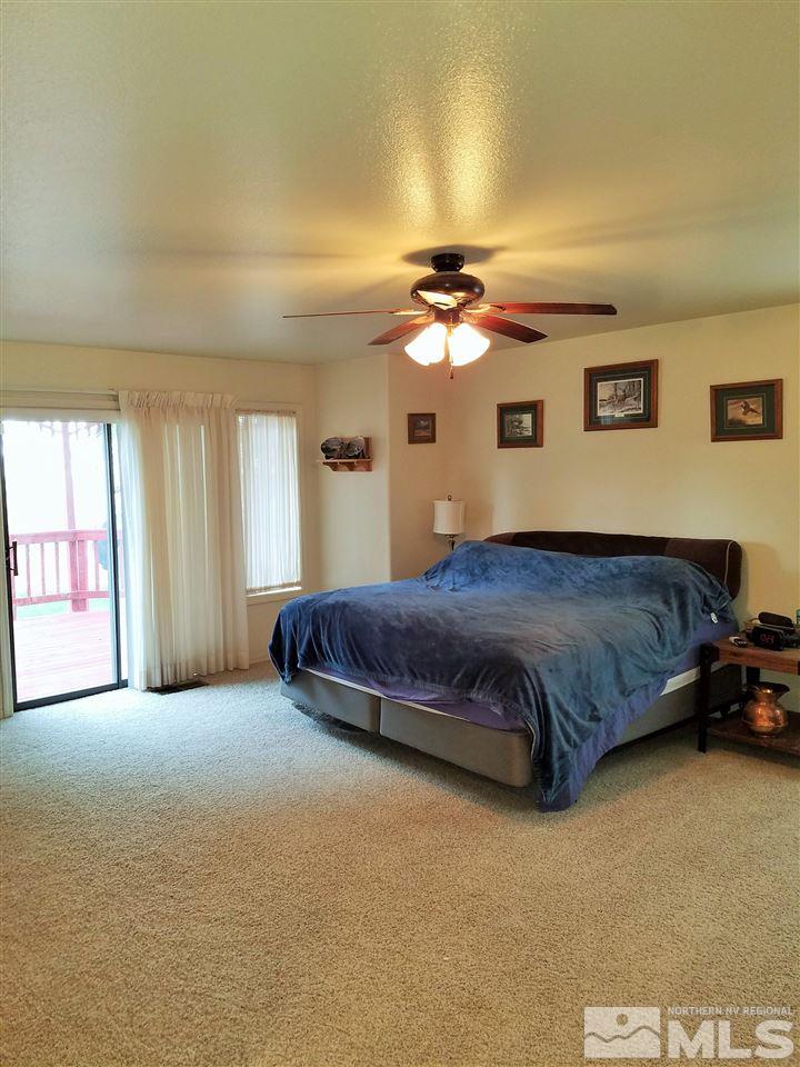 2580 Rice Road Fallon, NV 89406 - Photo 14 of 25 a spacious bedroom with a bed and a chandelier