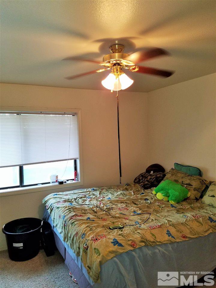 2580 Rice Road Fallon, NV 89406 - Photo 18 of 25 a bedroom with a bed and a chandelier