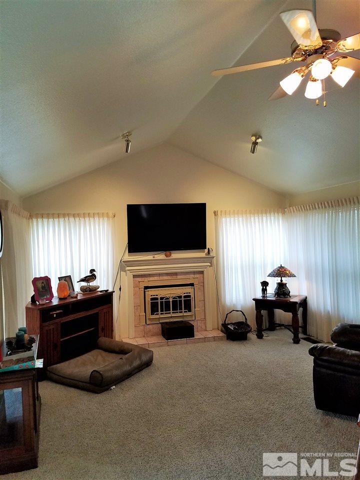 2580 Rice Road Fallon, NV 89406 - Photo 7 of 25 a living room with furniture a flat screen tv and a fireplace