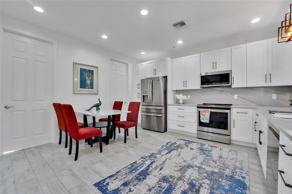 142 Morning Dew Circle, Unit 142 Jupiter, FL 33458 - Photo 13 of 34 a view of kitchen with sink microwave and cabinets