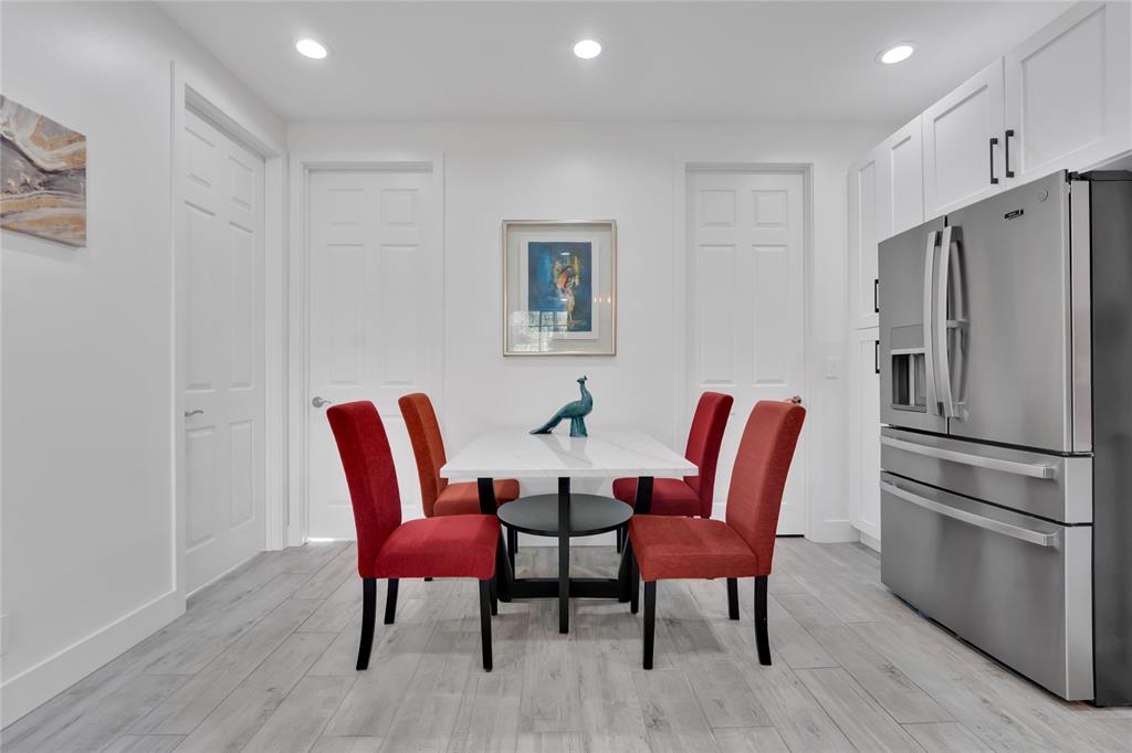 142 Morning Dew Circle, Unit 142 Jupiter, FL 33458 - Photo 14 of 34 a white kitchen with stainless steel appliances a refrigerator a table and chairs