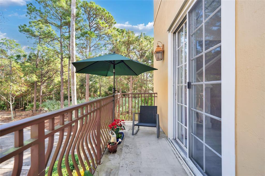 142 Morning Dew Circle, Unit 142 Jupiter, FL 33458 - Photo 3 of 34 a view of balcony with wooden floor and umbrella