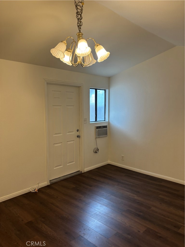 24627 B Moon Avenue Lomita, CA 90717 - Photo 2 of 7 a view of an empty room with wooden floor and a chandelier