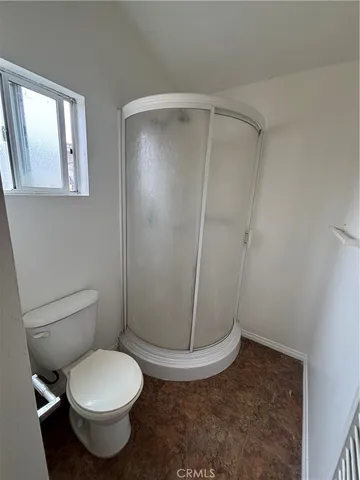 a white toilet sitting next to a shower