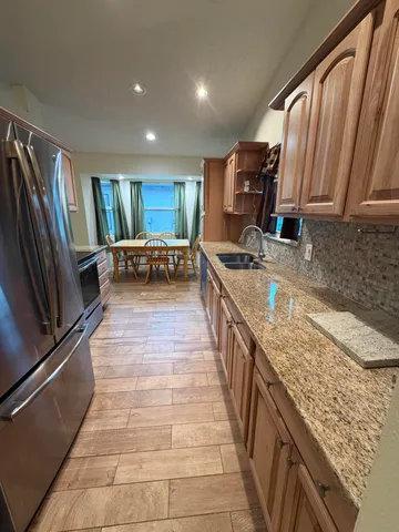 a kitchen with sink refrigerator and microwave