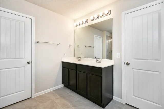 a bathroom with a double vanity sink and a mirror