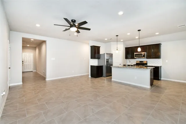 a view of kitchen with stainless steel appliances kitchen island microwave and cabinets
