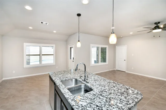 a kitchen with kitchen island a sink stove and wooden floor