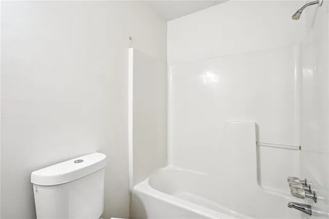 a white bath tub sitting next to a white toilet and sink