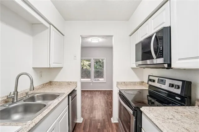 a kitchen with stainless steel appliances granite countertop a sink stove and microwave