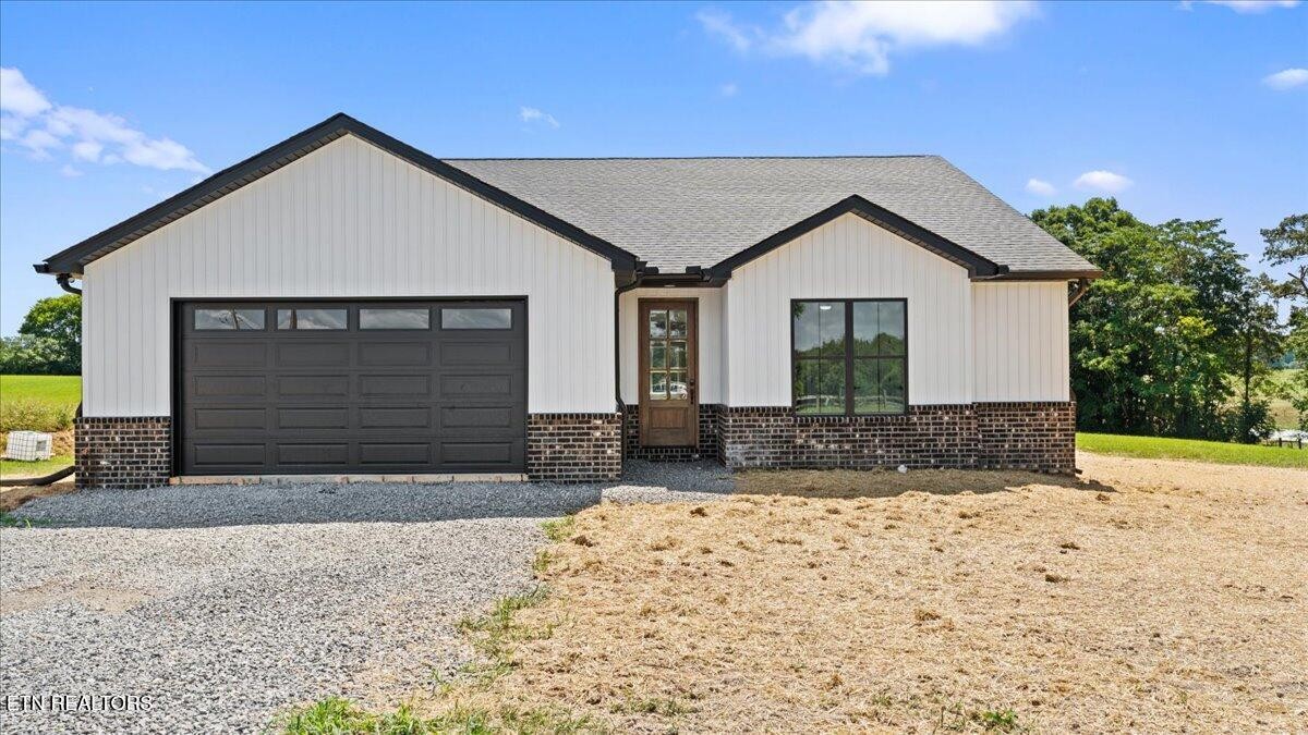 a view of house with yard and garage