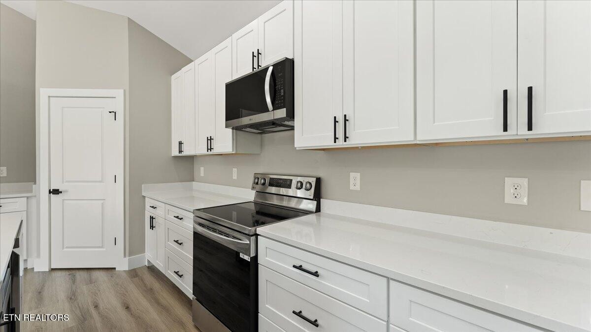 5817 Caldwell Road Loudon, TN 37774 - Photo 14 of 43 a kitchen with stainless steel appliances white cabinets and a stove top oven