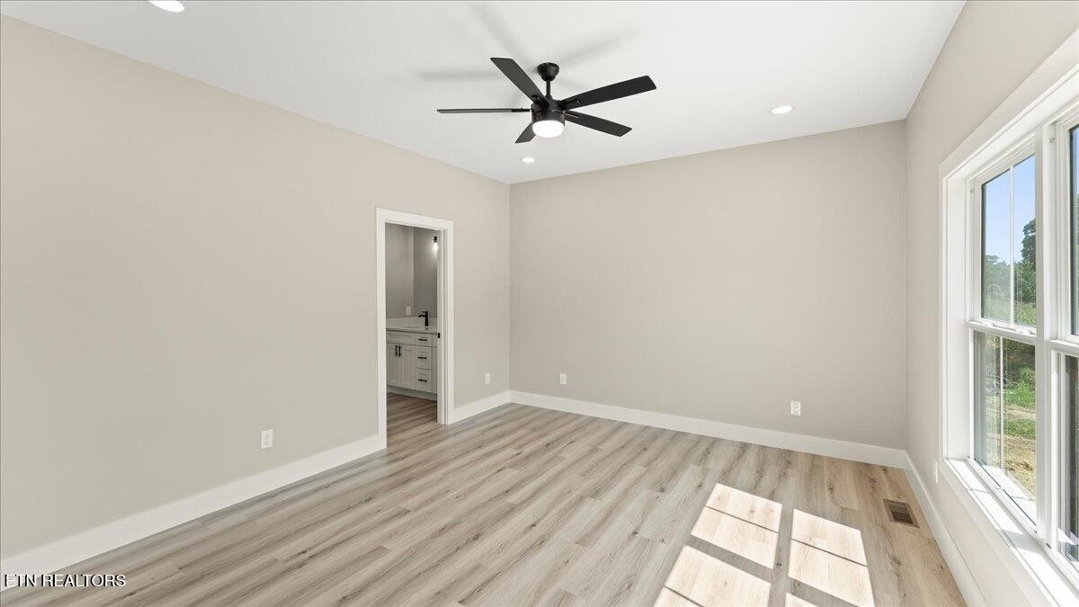 5817 Caldwell Road Loudon, TN 37774 - Photo 20 of 43 an empty room with wooden floor a ceiling fan and windows