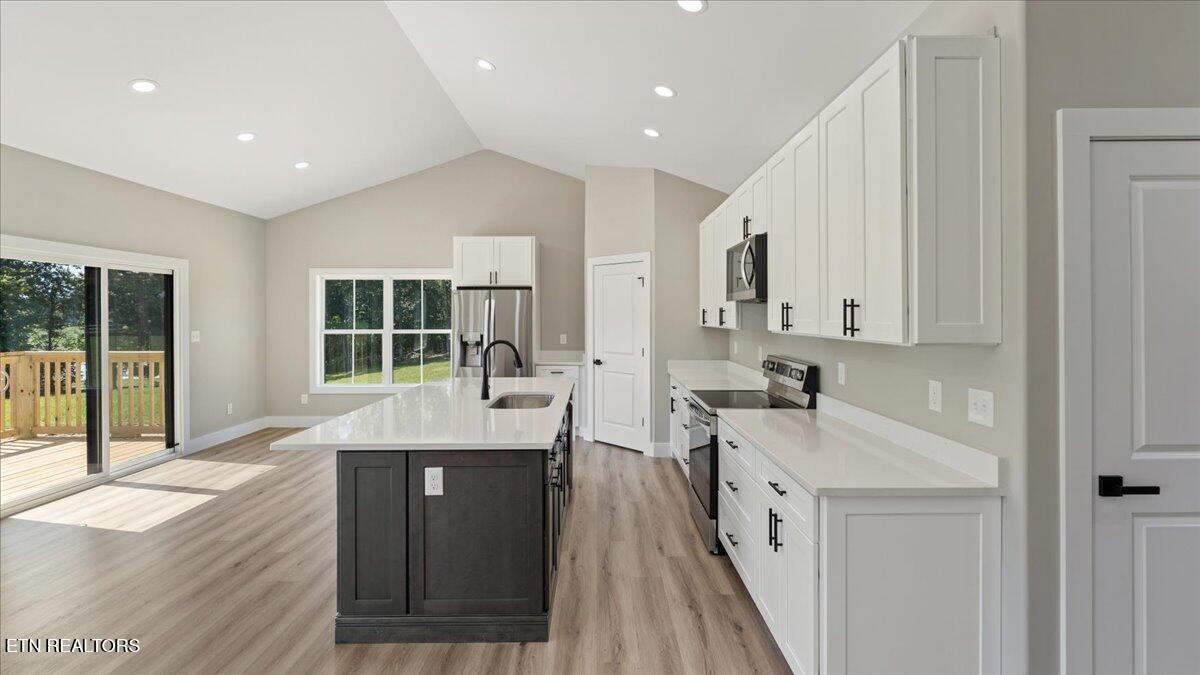 5817 Caldwell Road Loudon, TN 37774 - Photo 10 of 43 a large kitchen with kitchen island granite countertop a large window and stainless steel appliances