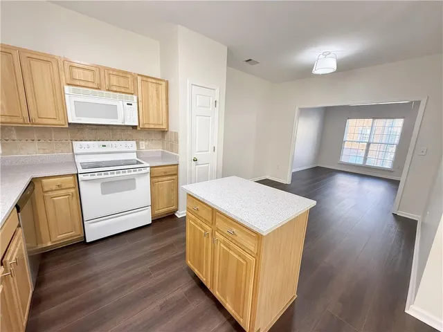 a kitchen with a stove top oven and a refrigerator