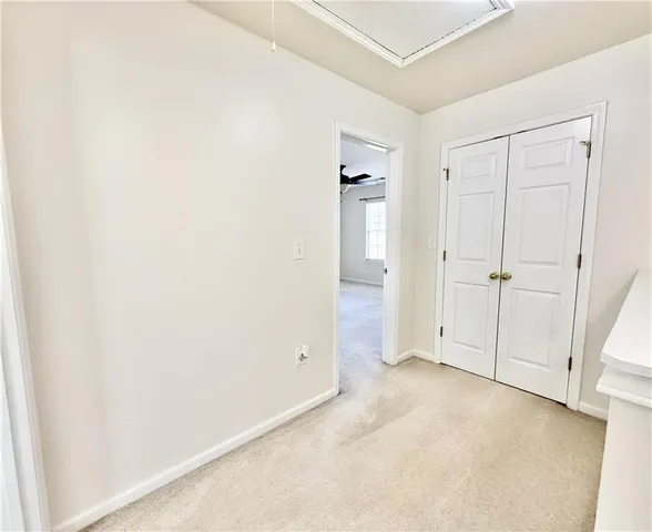 an empty room with white cabinet and mirror