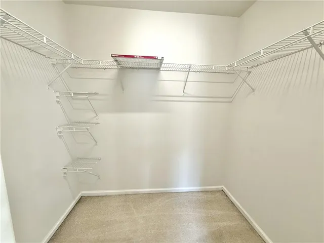a view of walk in closet with empty racks