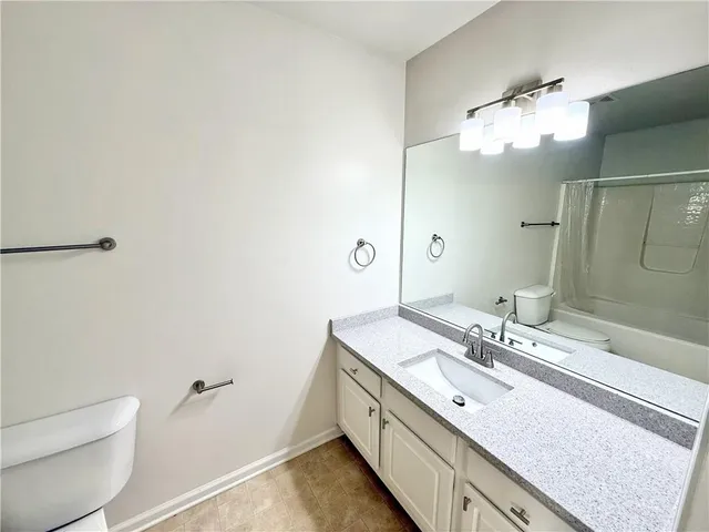 a bathroom with a double vanity sink mirror and toilet