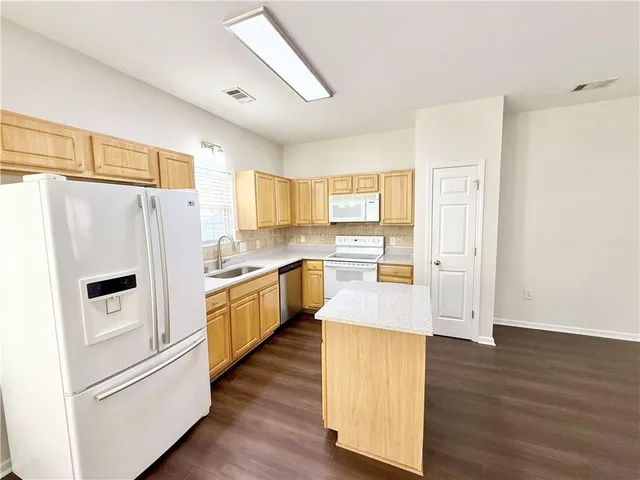 a kitchen with white cabinets and white stainless steel appliances
