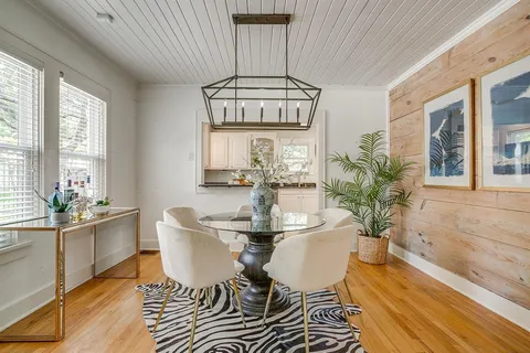 a dining room with furniture a chandelier and wooden floor